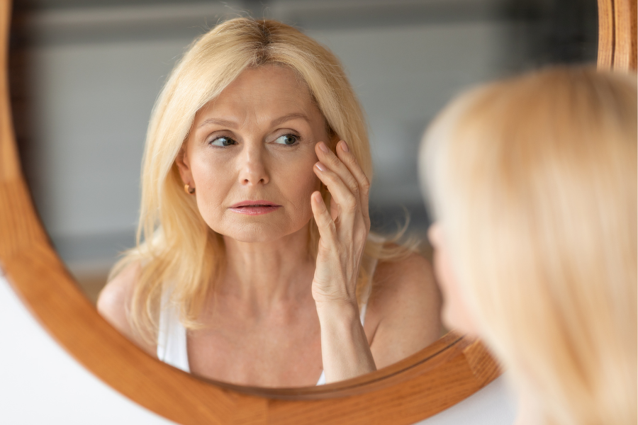 Young Woman with clean clear skin uses skincare to get rid of fine lines and wrinkles around the crows feet