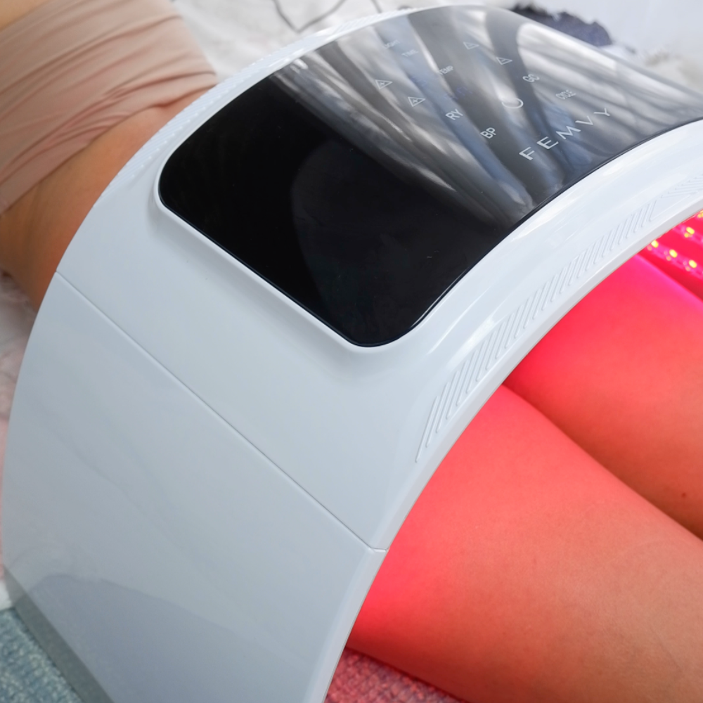 a woman using Femvy LED Light Therapy Pod